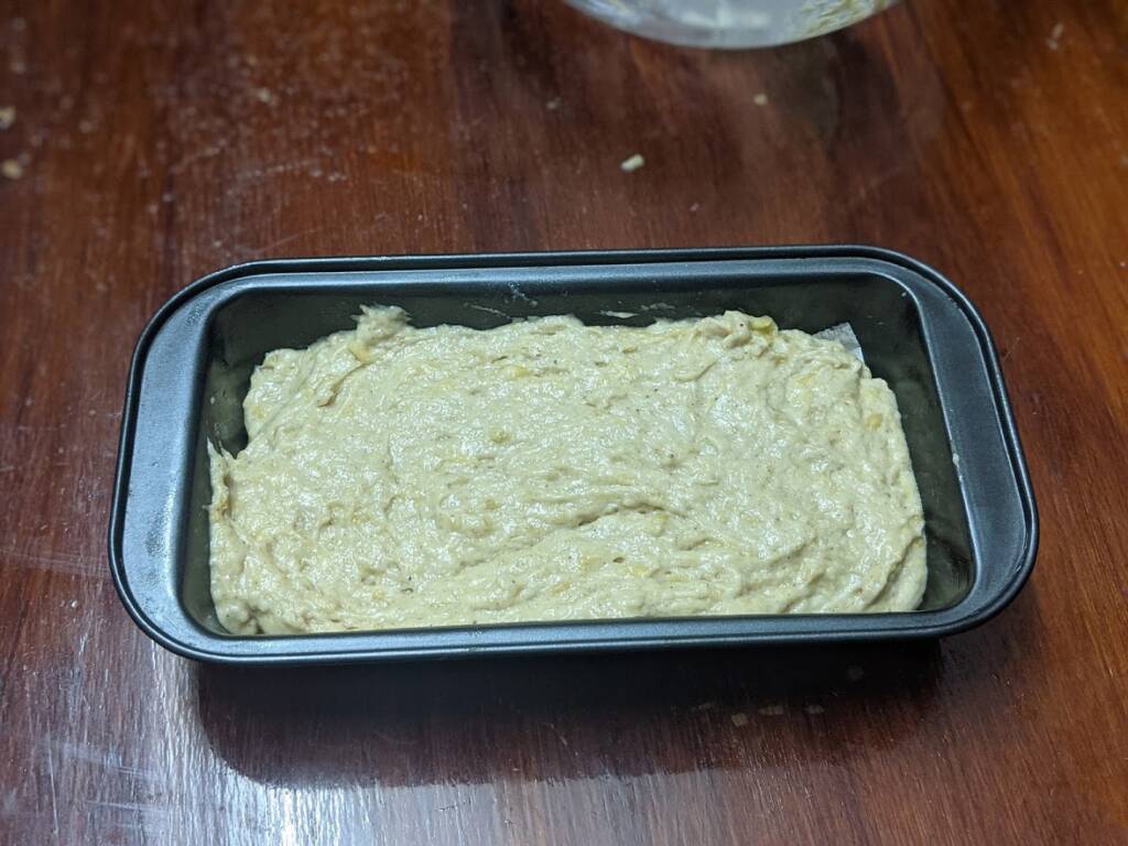 Grease a loaf pan with oil and line it with parchment paper and transfer the batter